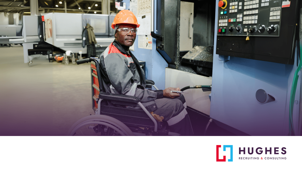 Man in safety vest and helmet operates manufacturing machinery from a wheelchair